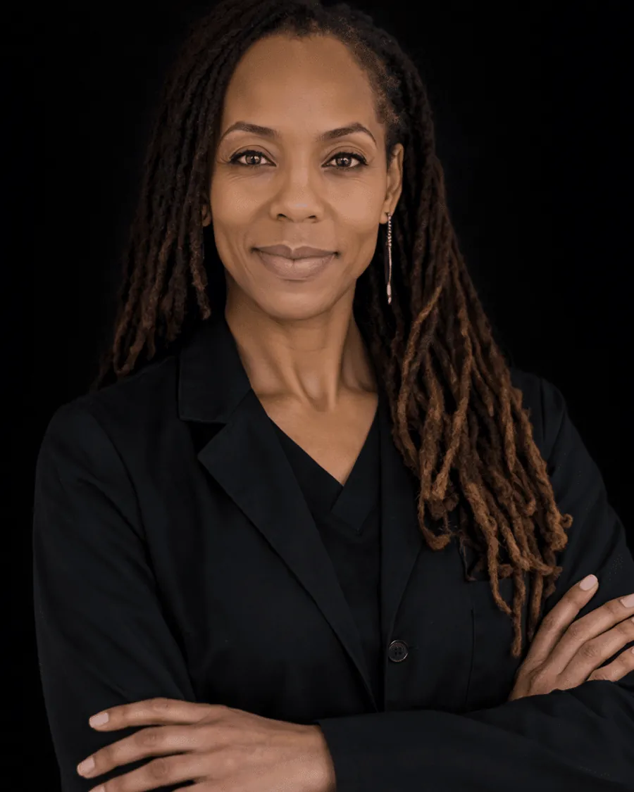 Dr. C. Allyson Walker standing with her arms crossed in a black blazer over scrubs.