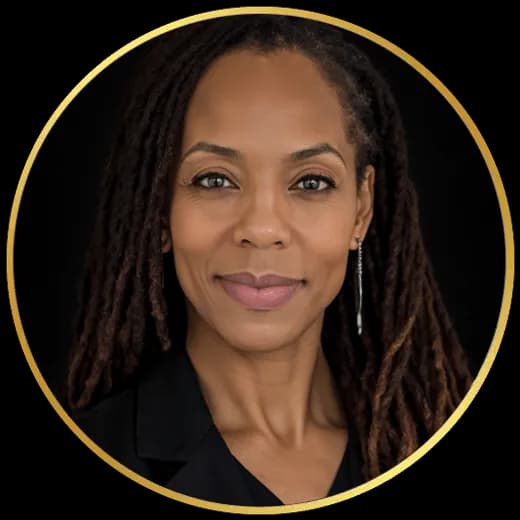 La Dra. C. Allyson Walker, fotografiada sobre un fondo oscuro con blusa negra y el cabello en locs.